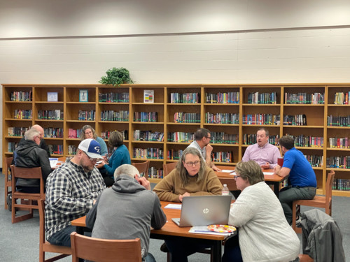 People talking at tables in library